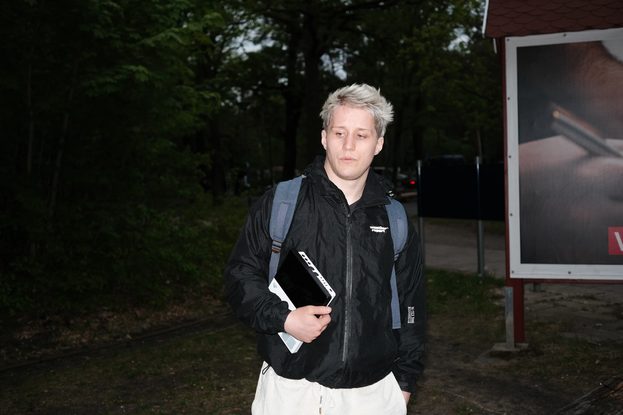 A person carrying a white FIRST LOVE instrument outdoors.